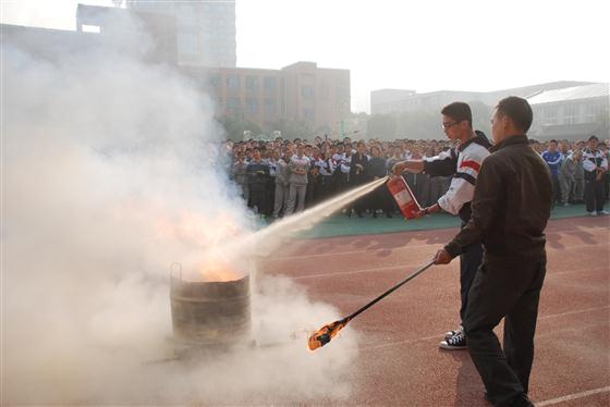 师生在专业人士指导下使用灭火器